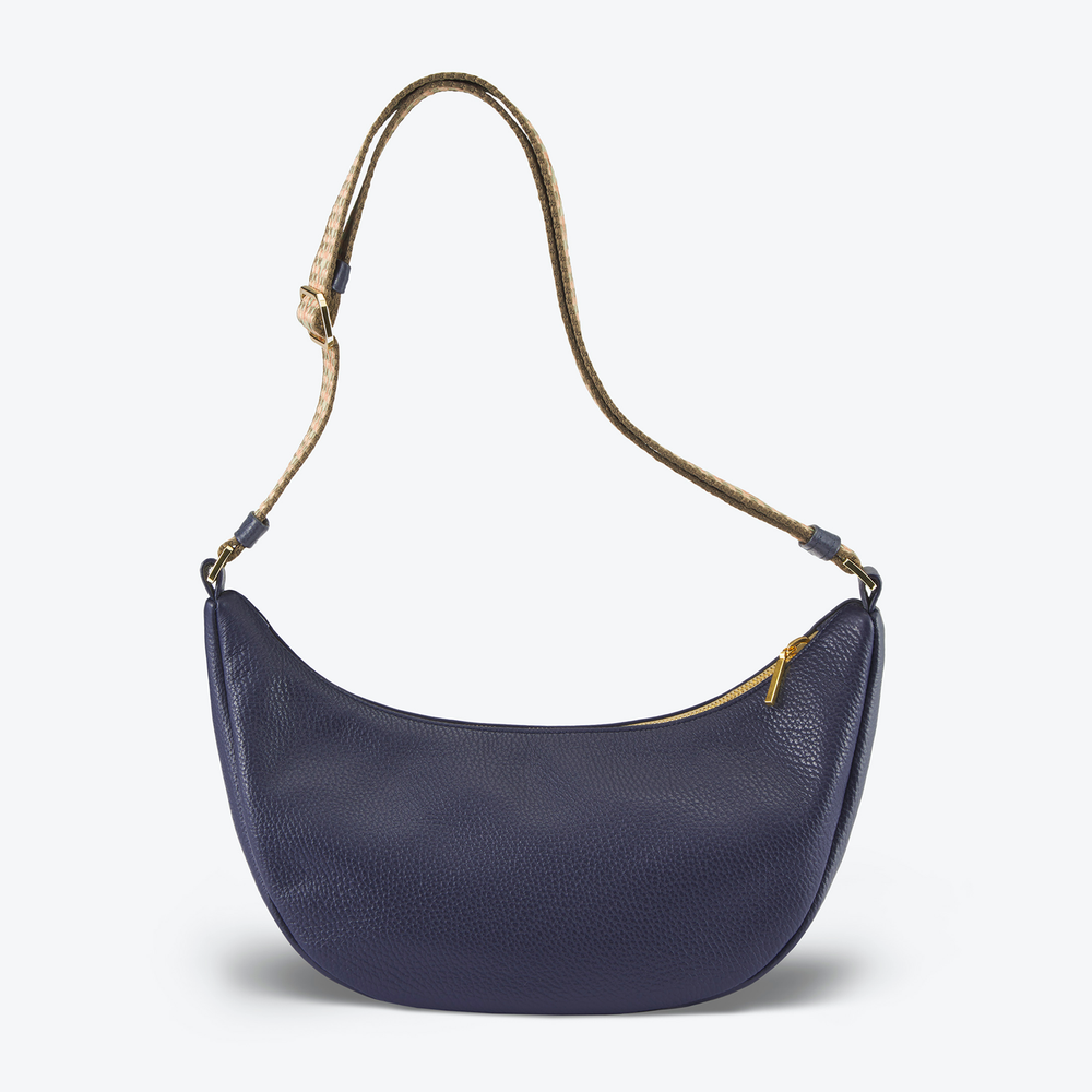 Luxury Half Moon handbag Navy Blue with a brown strap on a light gray background